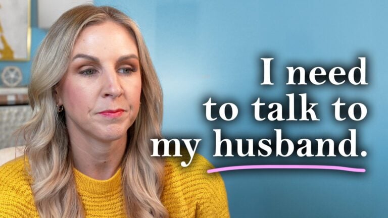 Stacy Tuschl with long blonde hair wearing a yellow sweater looks serious. Next to her, large white text reads, “I need to talk to my husband.” with “husband” underlined in pink. The background is blue.